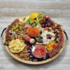 Royal (Serves 12–14): Includes 5–6 artisanal cheeses, 4 cured meats, fresh fruit, nuts, 1 dip or spread, honey and jam, olives, crackers, and a sweet treat. Tray or container is subject to availability and may vary in shape and material. Wooden boards available for rent.