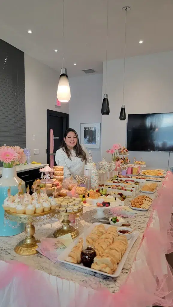 Veronica, founder of D’tapas Express, standing behind a grazing table setup in Orlando, Florida.